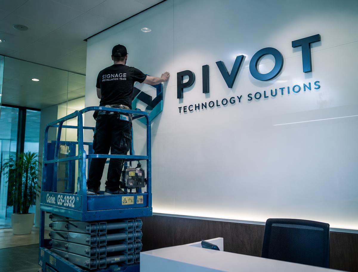 Installation team fitting dimensional lobby signage letters